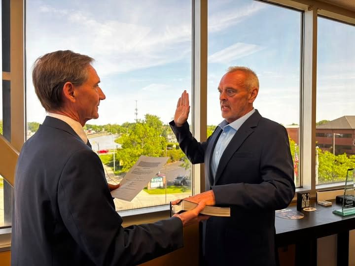 Muncie Mayor Dan Ridenour administers an oath of office to the city's new deputy mayor, Jeff Howe. Howe will also continue to serve as director of the Muncie Redevelopment Commission.