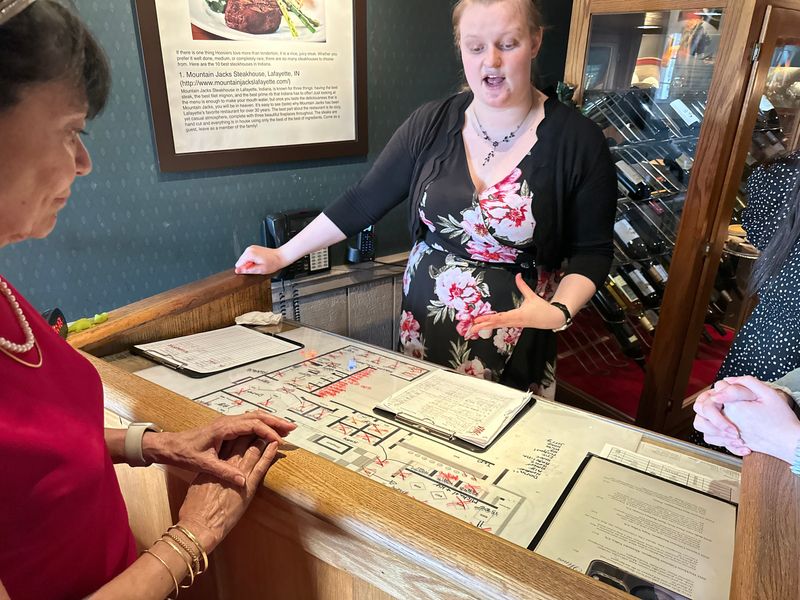 Manager Abby Bougher analyzes seating availability throughout Mountain Jacks during the restaurant's final dinner service. Bougher uses a color-coded system to identify tables that will soon become available for quicker turnover.