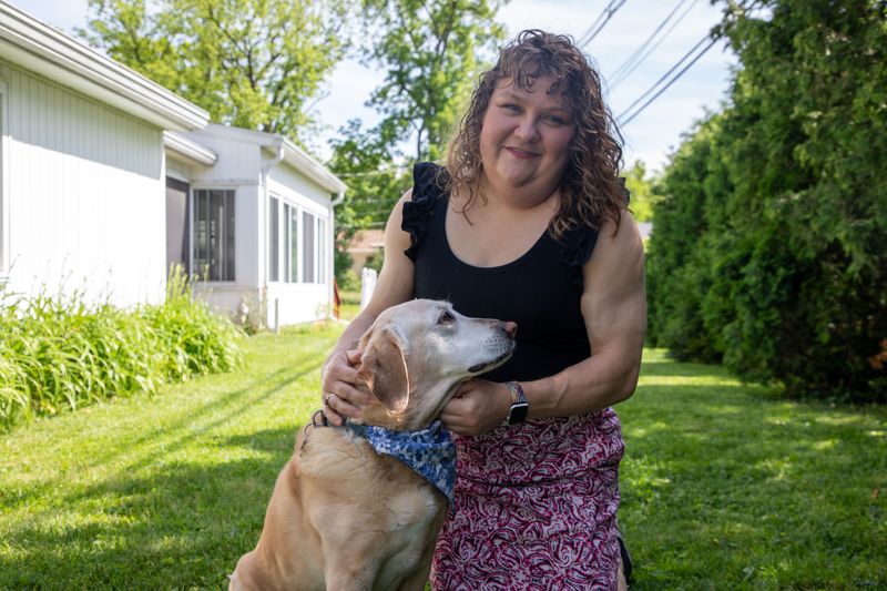 Suzanne Swierc plays with her 14-year-old lab-golden mix, Larson, at her home in Muncie, Indiana, on May 29. Swierc was fired from Ball State University in September 2025 after a private Facebook post about the death of conservative activist Charlie Kirk went viral.