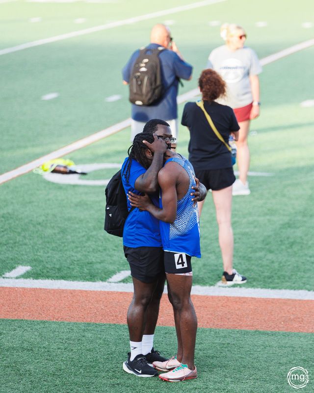 Elkhart boys track senior Alonzo Newbern, right, is embraced by his sprint coach, Dominique Holt, after being DQ'd during the 100-meter dash at the IHSAA regional Thursday, May 28, 2026, at Warsaw High School.