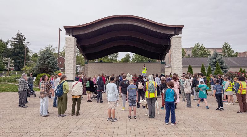 The middle school students in grades 6-8 at the Project School along with parents, teachers and administrators listen to speakers at the beginning of the first official tour of the Project School Walking Tour on May 21, 2026.