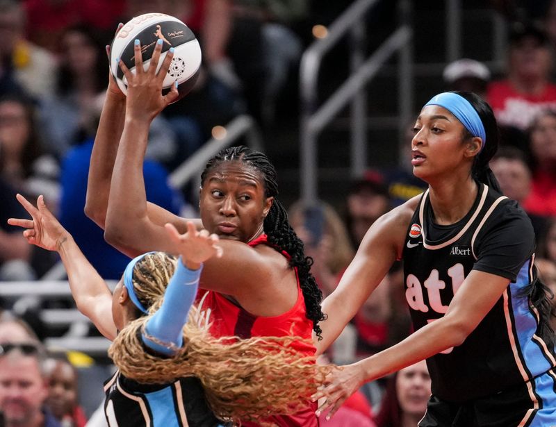 Indiana Fever forward Aliyah Boston (7) looks to pass against Atlanta Dream guard Jordin Canada (3) and Atlanta Dream forward Angel Reese (5) on Thursday, June 4, 2026, during the first half of a game at Gainbridge Fieldhouse in Indianapolis.