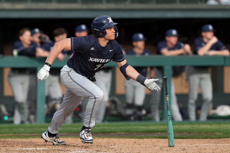 Feb 28, 2025; Stanford, CA, USA; Xavier Musketeers first baseman Connor Misch (32) hits a double against the Stanford Cardinal during the eighth inning at Sunken Diamond. Mandatory Credit: Darren Yamashita-Imagn Images