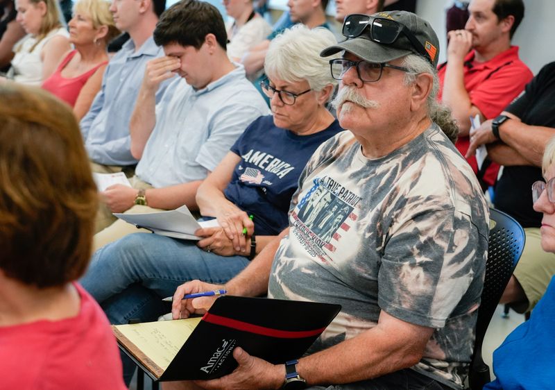 Brad Smith, right, takes notes next to his wife, Nancy Smith, second right, during a town hall meeting to discuss eliminating property taxes led by Rep. J.D. Prescott Tuesday, June 23, 2026, at the Glendale Public Library in Indianapolis.