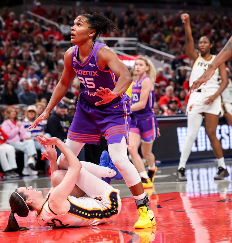 Indiana Fever guard Caitlin Clark (22) falls in the lane as Phoenix Mercury forward Alyssa Thomas (25) eyes the ball Wednesday, June 24, 2026, during the first half of a game at Gainbridge Fieldhouse in Indianapolis.