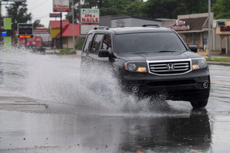 A vehicle splashes through high water on Green River Road Friday, June 26, 2026.