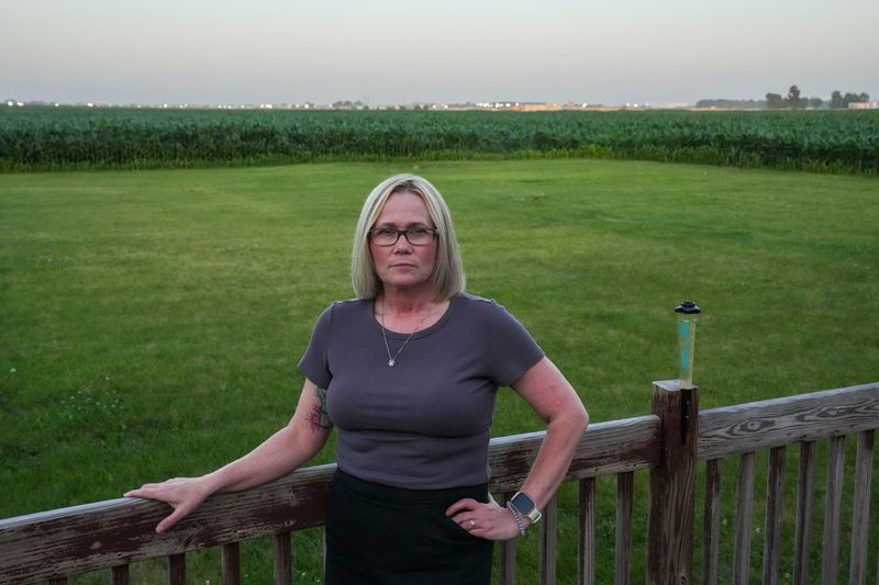 Boone County resident Leslie Hine stands on her porch Tuesday, June 30, 2026, just outside Meta's construction site at the LEAP district in Lebanon, Ind. Meta is working on an AI data center and some residents who live near the site say the construction disrupts their daily life.