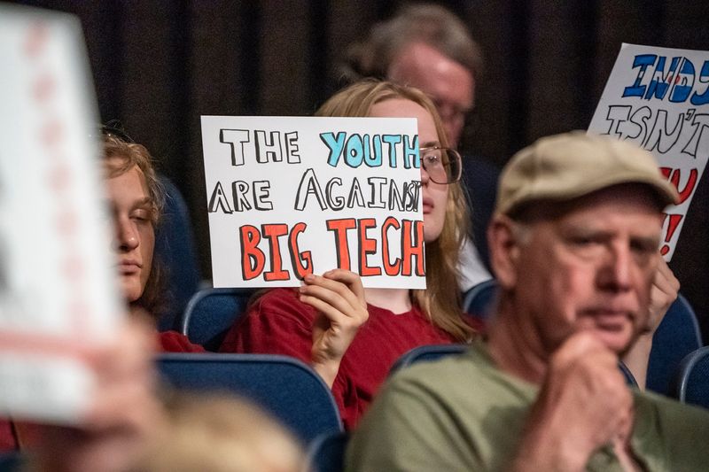 Members of the public hold protest signs asking for a moratorium of data centers during an Indianapolis Metropolitan Development Commission meeting in which controversial zoning regulations were discussed for data centers on Wednesday, July 1, 2026, at the City-County building in Indianapolis.