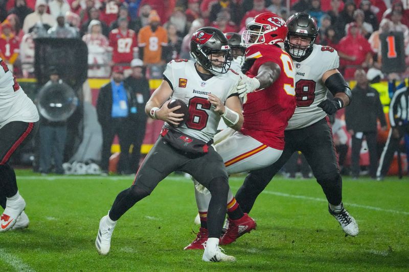 Nov 4, 2024; Kansas City, Missouri, USA; Tampa Bay Buccaneers quarterback Baker Mayfield (6) scrambles as Kansas City Chiefs defensive tackle Chris Jones (95) attempts the tackle during the second half at GEHA Field at Arrowhead Stadium. Mandatory Credit: Denny Medley-Imagn Images