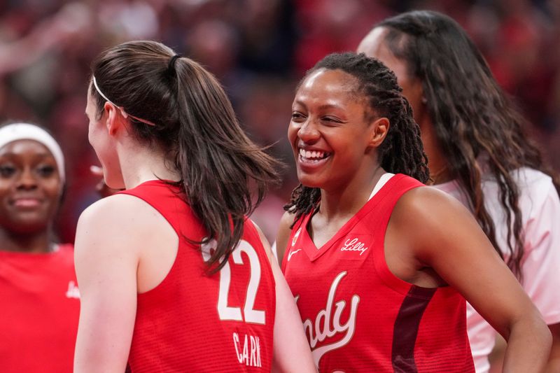 Indiana Fever guard Kelsey Mitchell (0) smiles at Indiana Fever guard Caitlin Clark (22) on Friday, July 17, 2026, during the second half of a game at Gainbridge Fieldhouse in Indianapolis. The Indiana Fever defeated the Seattle Storm, 110-107.