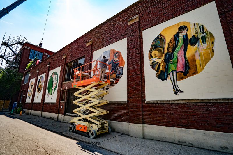 Artist Eric Fernung creates a multi-panel mural on the Real Silk Lofts building on Wednesday, July 22, 2026, in Indianapolis. The building once housed the Real Silk Hosiery company, which was known widely for making ladies' stockings. The images are inspired by advertisements from the 1920s.
