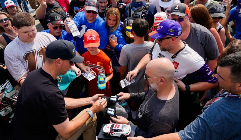 NASCAR Cup Series driver Denny Hamlin (11) autographs objects Sunday, July 26, 2026, ahead of the Brickyard 400 at Indianapolis Motor Speedway.