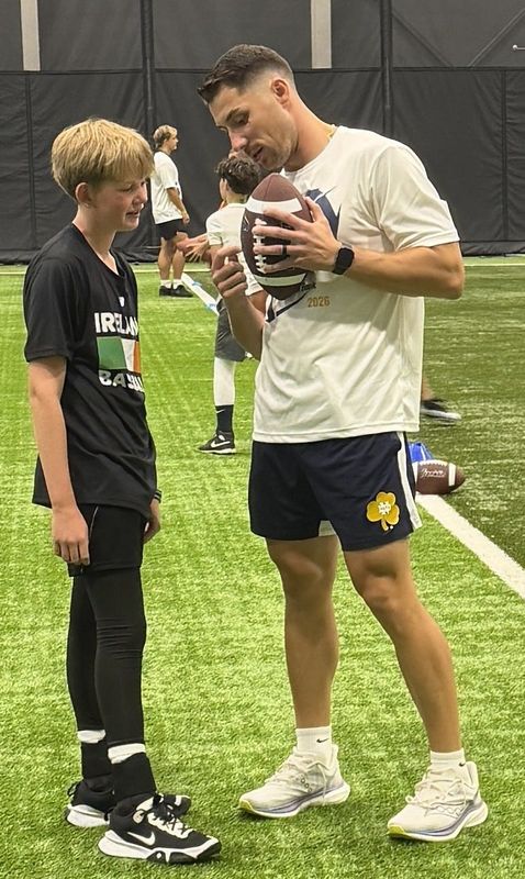 Former Notre Dame and NFL quarterback Ian Book (r) gives instruction to a young attendee at the OSMC-sponsored "Train Like a Pro" clinic on July 26, 2026 at the Mishawaka Fieldhouse.