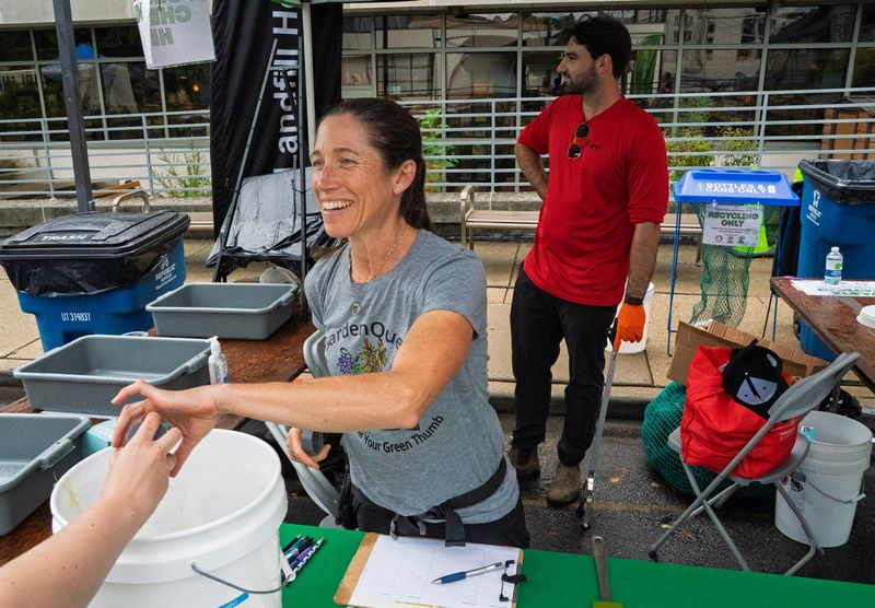 Ellee Spier works on collecting food waste to avoid putting it in the trash during Taste of Bloomington on Saturday, Aug. 1, 2026. A partnership between GardenQuest, Coca-Cola Consolidated, and Osprey organized the effort.