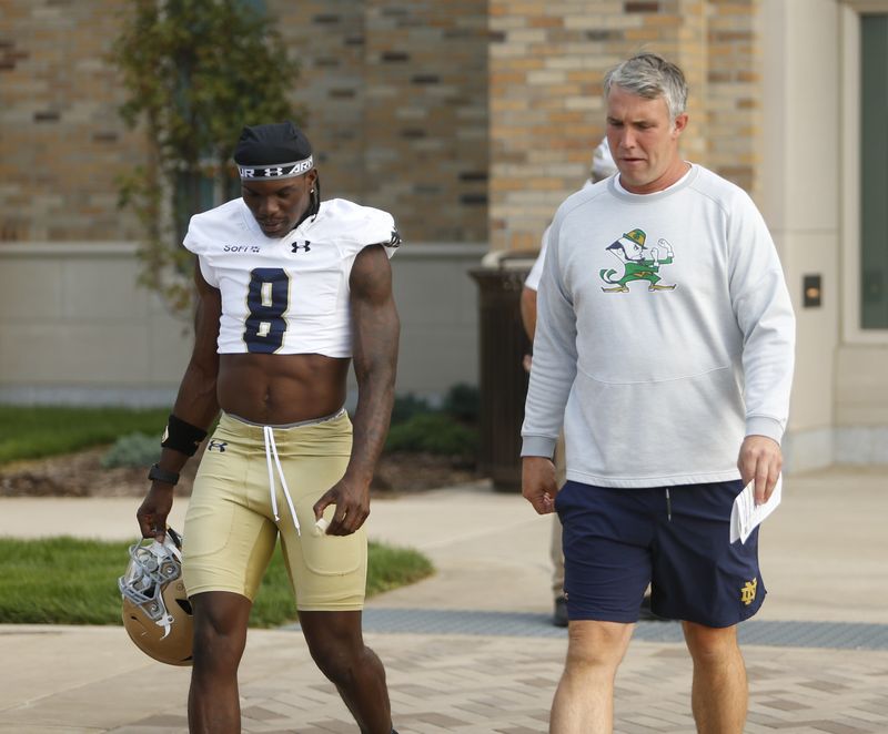 Notre Dame football senior Adon Shuler (8) and quarterbacks coach Gino Guidugli walk into practice Friday, Aug. 7, 2026, at the Irish Athletics Center in South Bend.