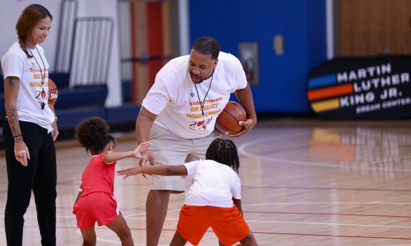 Former South Bend Washington girls basketball head coach Steven Reynolds Jr. instructs two elementary schoolers during Washington alumna Rashunda Jones' youth basketball camp at the Martin Luther King Jr. Dream Center Saturday, August 8, 2026.