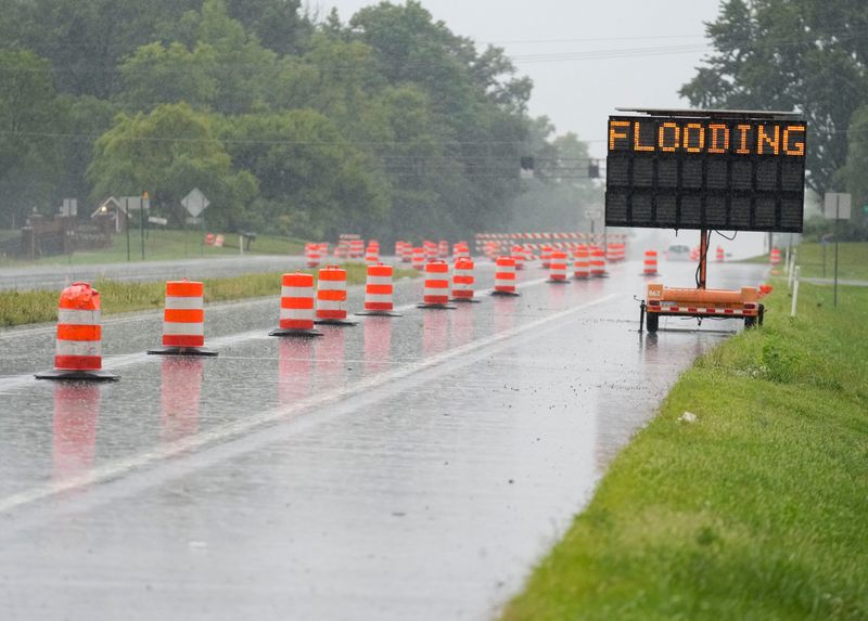 A sign warning travelers of flooding sits Wednesday, Aug. 12, 2026, along South Memorial Drive in New Castle, Ind.