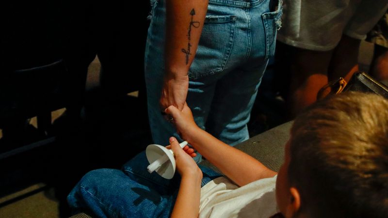 Attendees hold hands during Muncie resident Matthew Morey's candlelight prayer vigil Aug. 14 at Union Chapel. In light of the city's recent flood warnings, visitors were encouraged to hold their loved ones close.