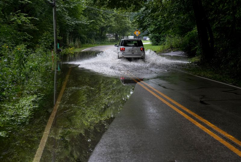 A car drives through floodwater on East Centenary Road on Monday, Aug. 17, 2026, in Morgan County.