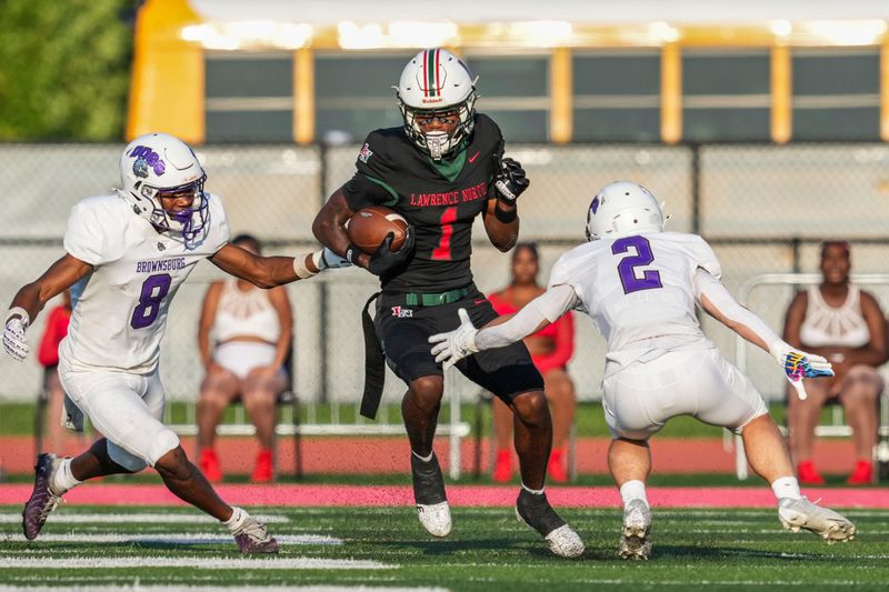 Brownsburg Bulldogs Trentin Russ (8) and Brownsburg Bulldogs Tye Morgan (2) guard Lawrence North Wildcats Monshun Sales (1) on Friday, Aug. 21, 2026, during a game at Lawrence North High School in Indianapolis.
