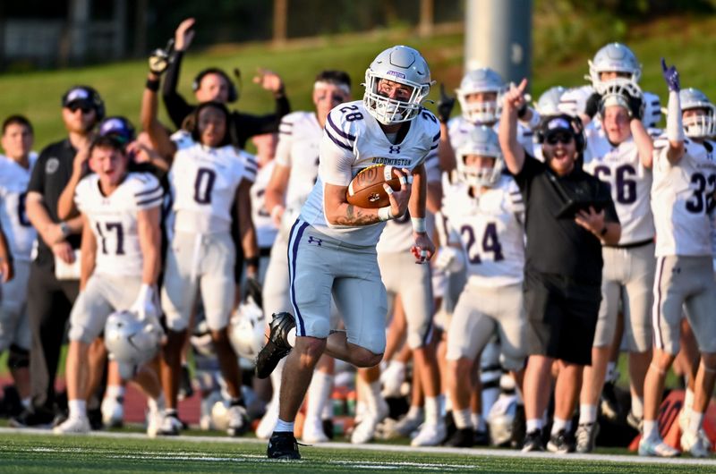 Bloomington South’s Tristan Wilson (28) returns an interception for a touchdown during the North-South football game at Bloomington North on Friday, Aug. 21, 2026.