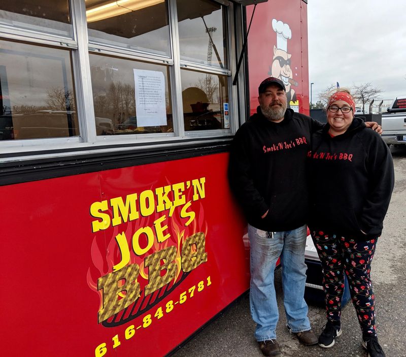 Brandon Kury and his wife, Becky, pose for a photo outside Smoke'N Joe's in 2022.