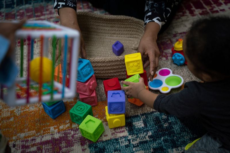 Co-owner Jacqueline Fordham, 59, stacks blocks with 11-month-old Brandon H., at Cribs2College Academy child care center in Detroit on April 5, 2023.