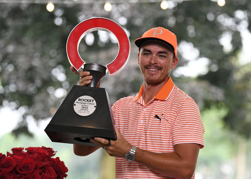 Rickie Fowler holds up the trophy after winning the 2023 Rocket Mortgage Classic at Detroit Golf Club in Detroit.