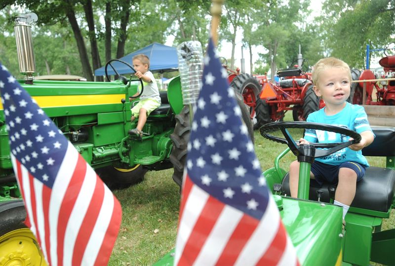 Friends Maddex Shotwell (left), then 4, and Dylan Turner, then 3, of Monroe got a chance to sit in some of the tractors on display during a previous Southeast Michigan Antique Tractor and Engine Show. The association will hold a show June 14 in Monroe.