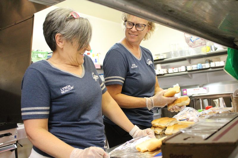 Volunteering at God Works Family Soup Kitchen, Realtors Lynda Nickelson, left, and Kris Hudson prepare a meal for the homeless and working poor in Monroe County. Several God Works meals and food pantries are available to Monroe County people in need of food.