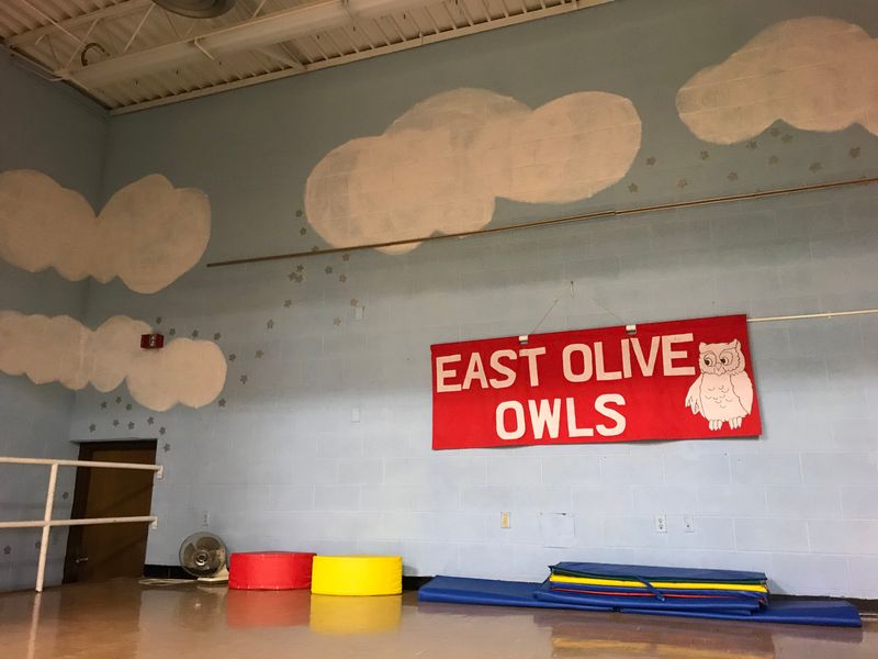 A sign that reads "East Olive Owls," hangs on the stage in the former East Olive Elementary School on Monday, Oct. 29, 2018. The building will reopen as East Olive Community Center on Nov. 3.
