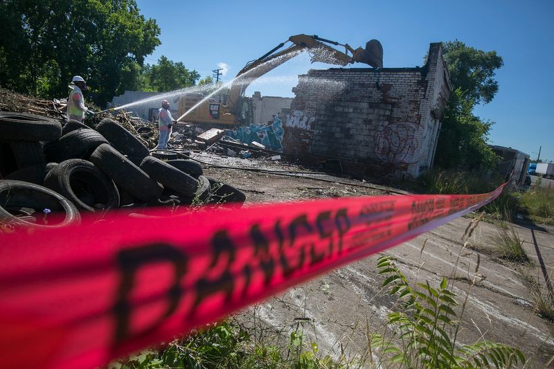 Gayanga Co. laborers Richard Allen of Detroit, left, and Eric Cox of Detroit wet down a demolition on Detroit's west side on Monday, July 9, 2018. Detroit's Land Bank demolition program seriously lacks diversity. Just 16% of the hundreds of millions in federal dollars awarded since 2014 have gone toward Black-owned companies. Gayanga Co. has received more than $4 million in contracts and nearly 90% of its staff are Detroit residents. We follow them on a commercial demolition on Detroit's west side.