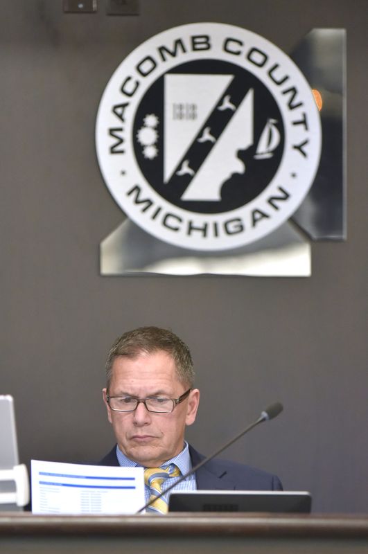 Bob Smith, then Macomb County Board of Commissioners chair, looks at paperwork during a 2019 meeting.
