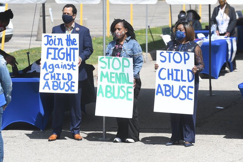 The Rev. Damon Dillard, left, Dawn Floyd, My Sistah’s Pink Journey, and Alana Dillard hold signs during the Child Abuse Prevention and Mental Health Awareness Rally on Saturday, May 1, 2021.