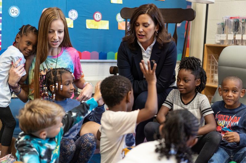 Michigan Gov. Gretchen Whitmer gives fives after taking a photo with first-grade students after stopping in their classroom during a visit at Forest Park Elementary in Eastpointe on Monday, Aug. 28, 2023.