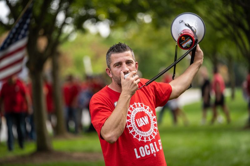 UAW Local 51 Vice President Luigi Gjokaj leads members in chants while marching during a UAW practice picket at Stellantis headquarters in Auburn Hills on Wednesday, September 20, 2023.