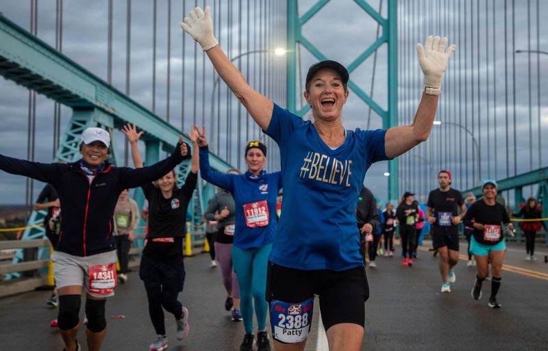 Marathon runner Patricia Raines smiles as she jogs across the Ambassador Bridge early in the morning during the 46th Annual Detroit Free Press Marathon presented by MSU Federal Credit Union in Detroit on Sunday, Oct. 15, 2023.