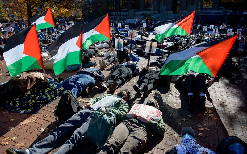University of Michigan student protestors lie on the ground during a 'Die In' demonstration on the Ann Arbor campus Diag, some holding Palestinian flags, protest signs and photos of the victims of the war in Israel, where more than 10,000 Palestinians have been killed in the past month.