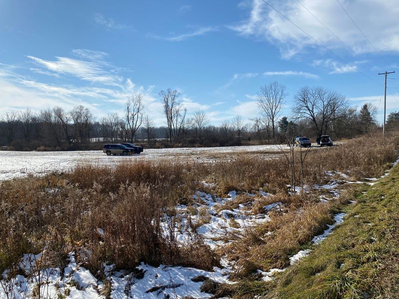 Investigators' vehicles are pictured Thursday, Nov. 30, 2023, in a field where Lenawee County Sheriff Troy Bevier said a hunter was shot by another hunter.