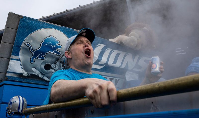 Detroit Lions fan Mark Mullins cheers on the crowd as he sits inside a hot tub early morning at Eastern Market during a tailgate before the Lions game against Tampa Bay on Sunday, Jan. 21, 2024.