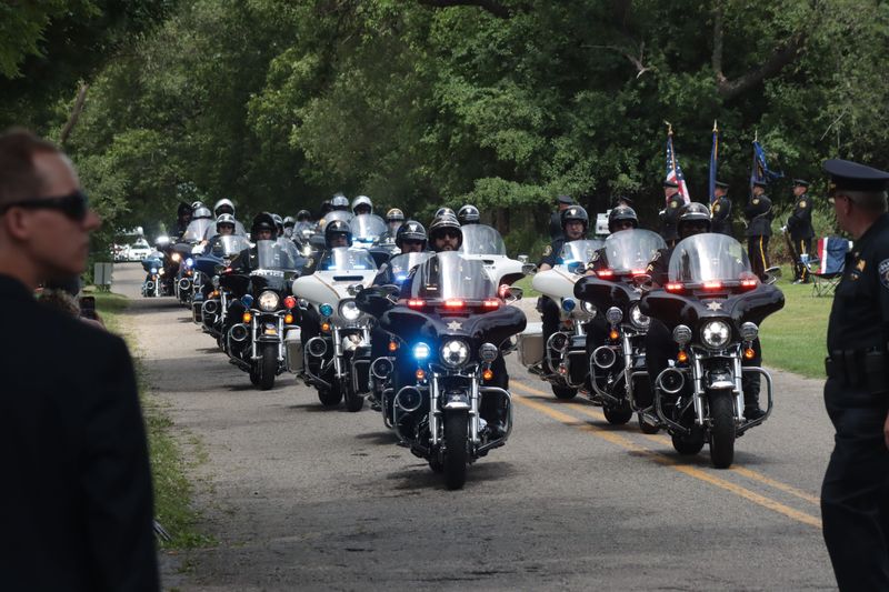 Motorcycle officers escort a hearse carrying the late Hillsdale County Sheriff's Deputy William Butler Jr. in July 2024.