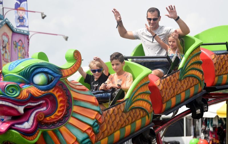 Mark Benedettii rides the Orient Express ride with his two children, Eva, then 6, and Evan, then 8, and Owen Mitchery, then 4, at the 2024 Monroe County Fair. This year's Monroe County Fair is July 27-Aug. 2. The fair is one of many summer events planned for Monroe County and other local regions in July.