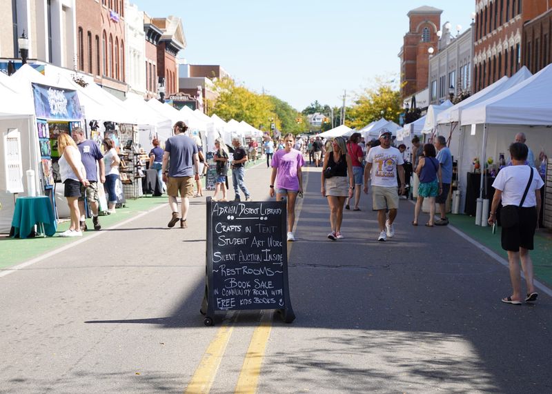 The Artalicious Fine Arts Fair returned for its 17th edition to downtown Adrian during the weekend of Saturday, Sept. 21 and Sunday, Sept. 22, 2024. People are seen checking out the artists' booths lining Maumee Street looking east from Main Street.