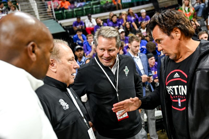 From left, Michigan State Athletic Director Alan Haller, basketball coach Tom Izzo, President Kevin M. Guskiewicz and Pistons' owner Tom Gores talk before the exhibition game against the Suns on Tuesday, Oct. 8, 2024, at the Breslin Center in East Lansing.