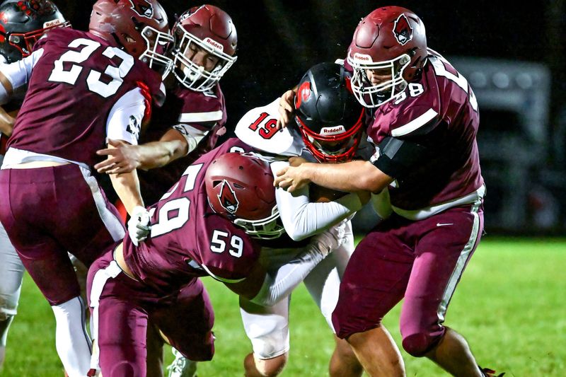 Portland's Barrett Spitzley, left, and Thomas Perron, right, tackle Sexton's quarterback Aspen Keyes during the second quarter on Friday, Oct. 18, 2024, at Portland High School.