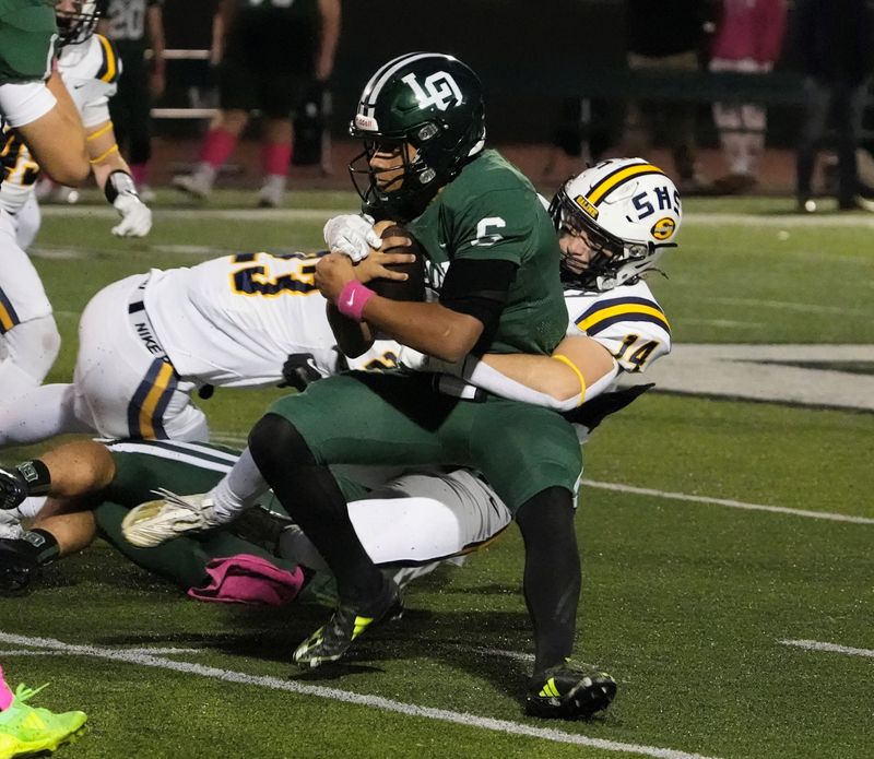 Saline linebacker Bryce Barbarino sacks Lake Orion quarterback Tristan Hill during the first quarter at Lake Orion High School in Lake Orion on Friday, Oct. 25, 2024.