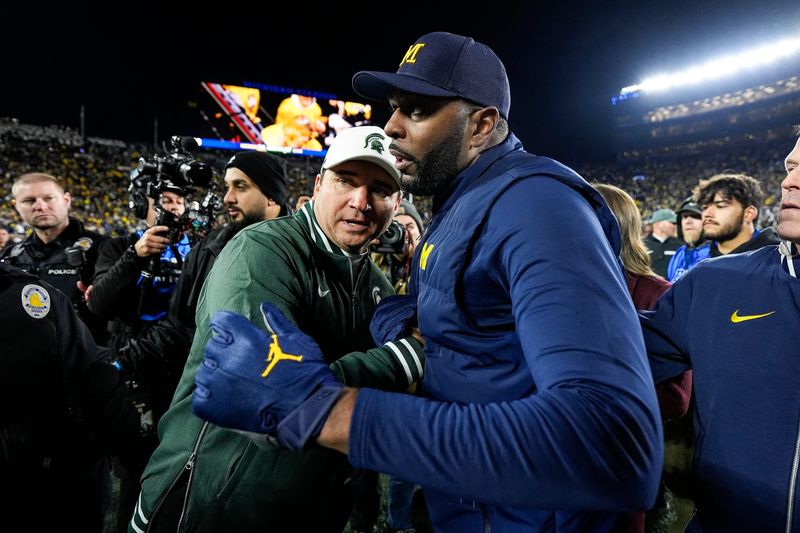 Michigan State head coach Jonathan Smith, left, shakes hands with head coach Sherrone Moore after 24-17 loss at Michigan Stadium in Ann Arbor on Saturday, Oct. 26, 2024.