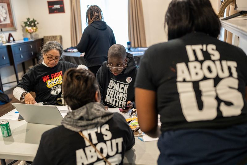 Char Goolsby, center, of Detroit, talks with people helping dispatch a group to knock on doors to get residents to get out and vote for the 2024 presidential election at her home in Detroit on Monday, Nov. 4, 2024.