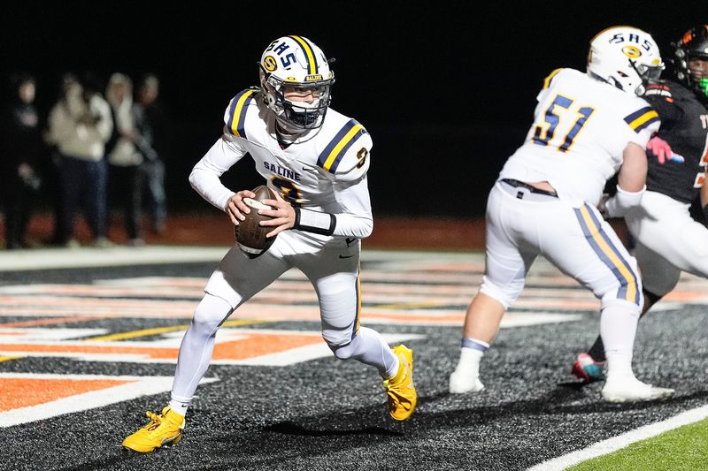Saline quarterback Tommy Carr looks to pass against Belleville during the first half of district final at Belleville High School in Belleville on Friday, Nov. 8, 2024.