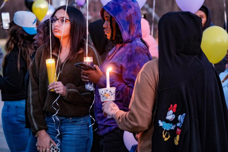 People attending the candlelight vigil and balloon launch for three of last Saturday's deadly crash on I-96 near Webberville, begin to light their candles Friday, Nov. 8, 2024. Over 100 people attended the gathering at Benjamin Davis Park in Lansing.